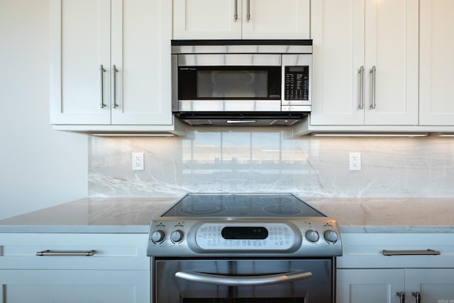 kitchen with backsplash, appliances with stainless steel finishes, light stone counters, and white cabinets