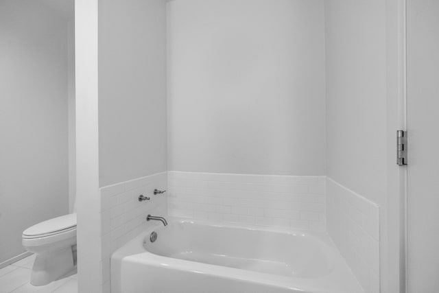 bathroom featuring tile patterned floors, toilet, and a bathtub