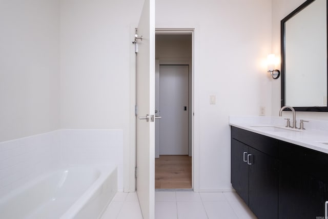 bathroom featuring vanity, a tub to relax in, and tile patterned flooring