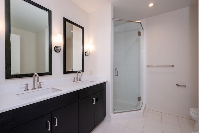 bathroom featuring vanity, a shower with door, tile patterned floors, and toilet