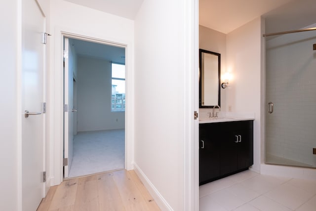 interior space with vanity, hardwood / wood-style flooring, and a shower with shower door