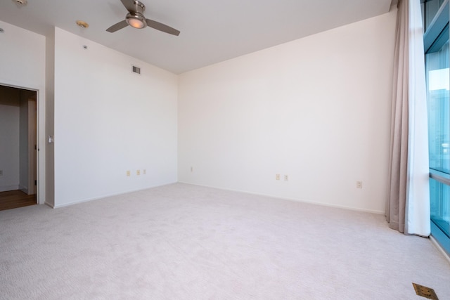 spare room featuring light carpet and ceiling fan