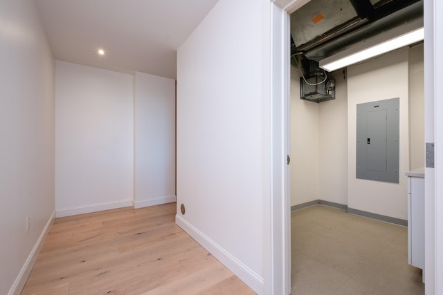 hallway with electric panel and light wood-type flooring