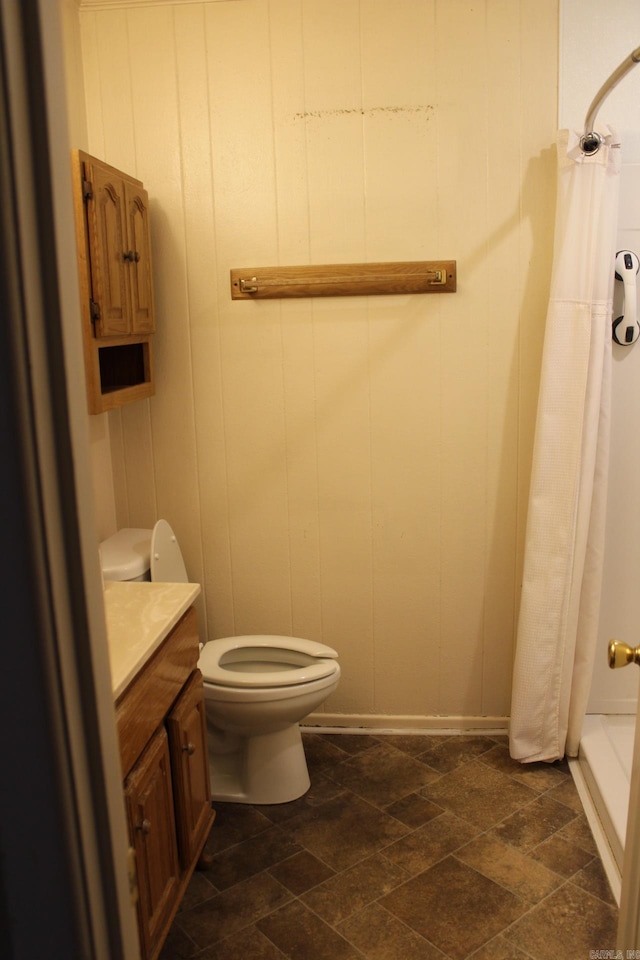 bathroom featuring toilet, vanity, and walk in shower