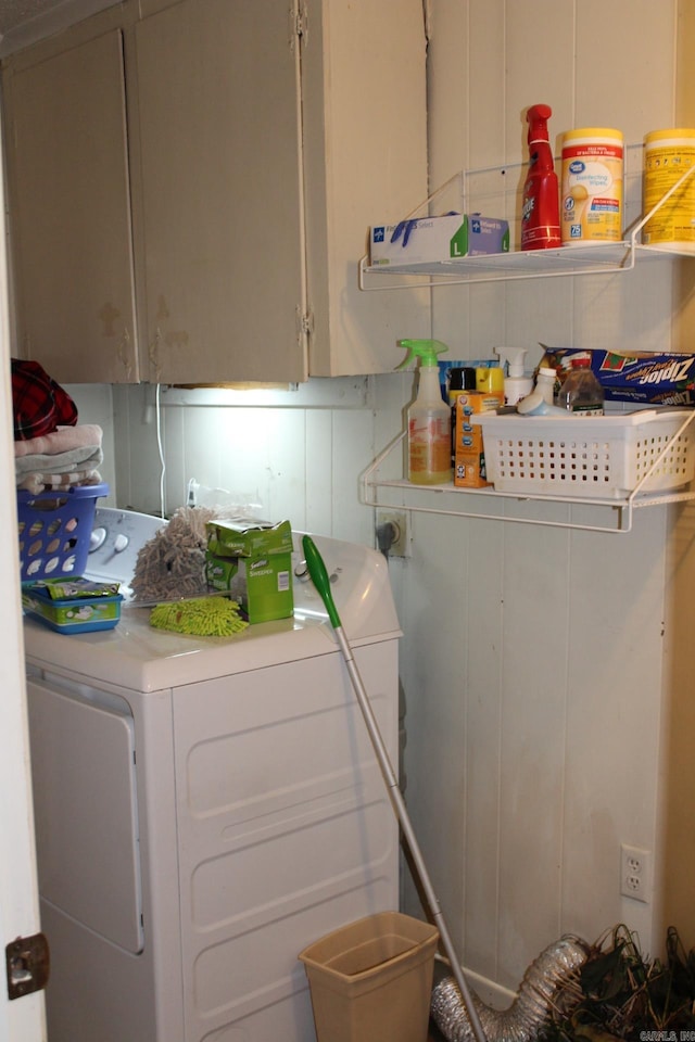 clothes washing area with cabinets and washing machine and dryer