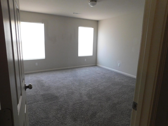 carpeted spare room featuring a wealth of natural light