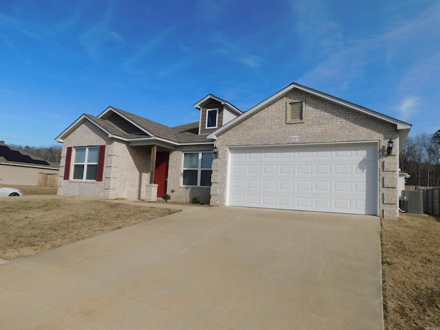 view of front of property featuring a garage and central AC