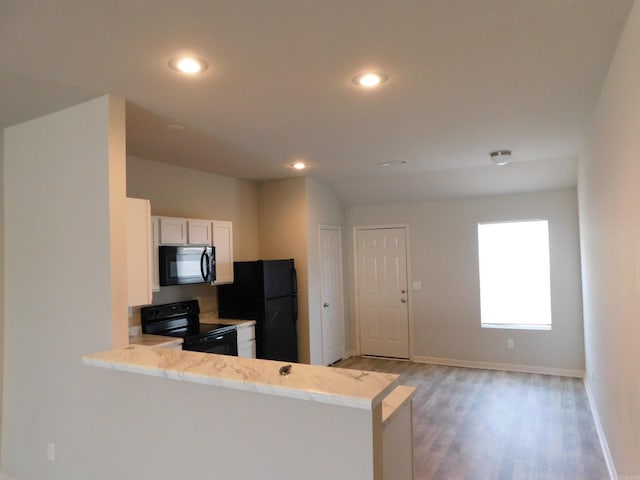 kitchen featuring white cabinetry, light hardwood / wood-style floors, black appliances, and kitchen peninsula