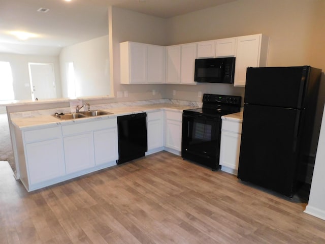 kitchen with white cabinetry, sink, black appliances, and light wood-type flooring