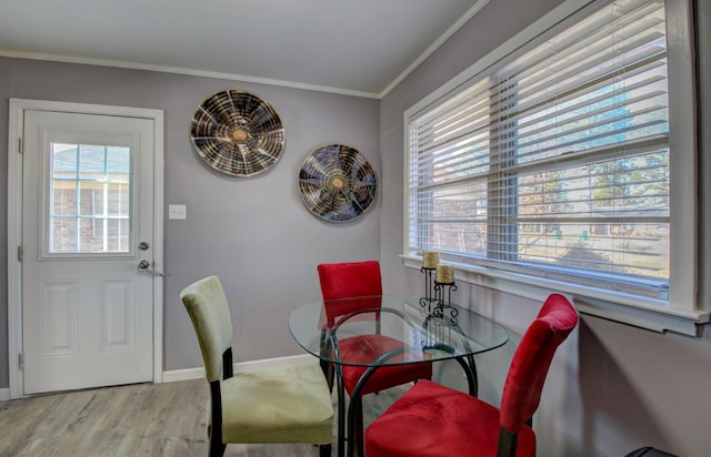 dining space featuring ornamental molding and light wood-type flooring