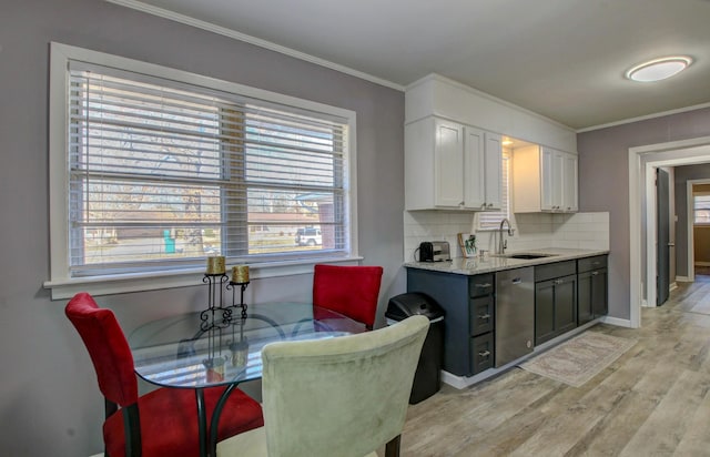 kitchen featuring tasteful backsplash, dishwasher, sink, white cabinets, and light wood-type flooring