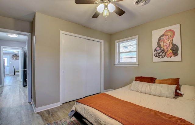 bedroom featuring ceiling fan, a closet, and light hardwood / wood-style flooring