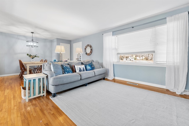 living room featuring hardwood / wood-style floors and a notable chandelier