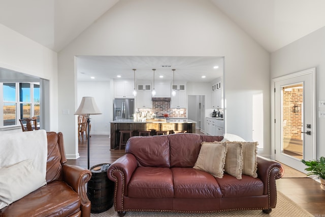 living room with dark wood-type flooring and high vaulted ceiling
