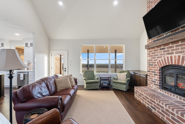 living room featuring lofted ceiling, dark hardwood / wood-style flooring, and a brick fireplace