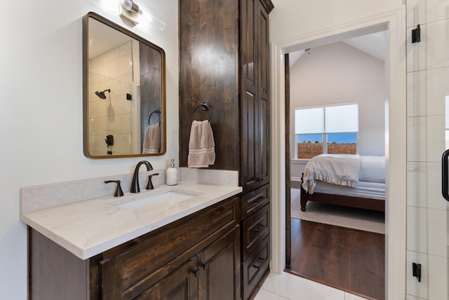 bathroom with walk in shower, vanity, tile patterned flooring, and vaulted ceiling