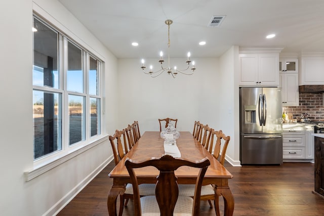 dining room with a water view, dark wood-type flooring, and a chandelier