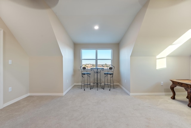 additional living space featuring lofted ceiling, light carpet, and a wealth of natural light