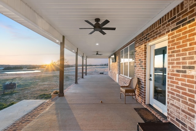 patio terrace at dusk featuring ceiling fan