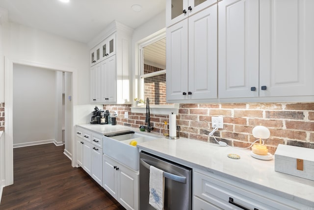 kitchen featuring dishwasher, sink, white cabinets, light stone countertops, and dark wood-type flooring