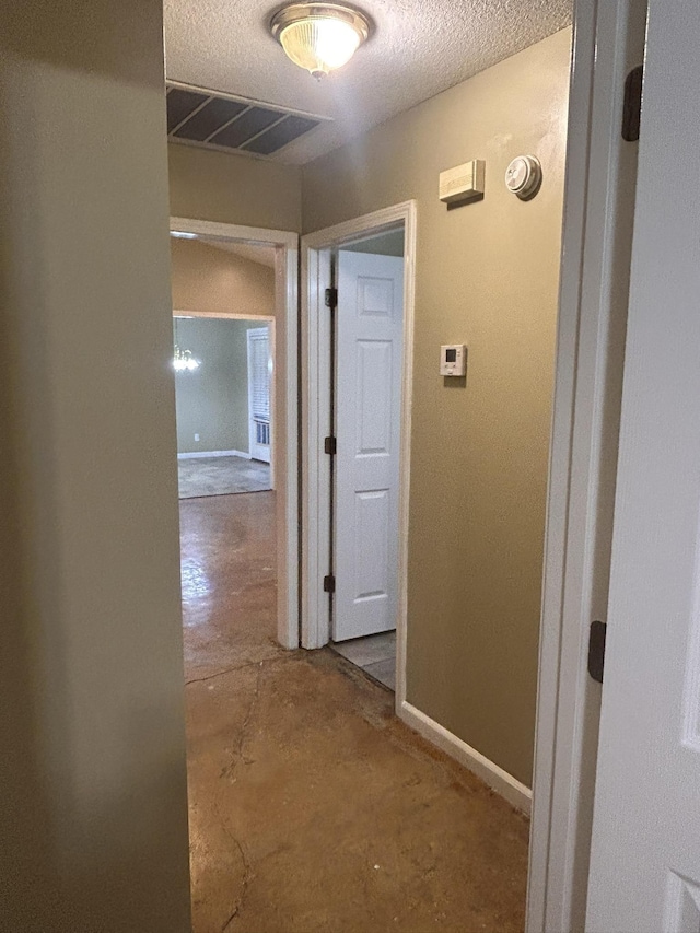 hall with a textured ceiling