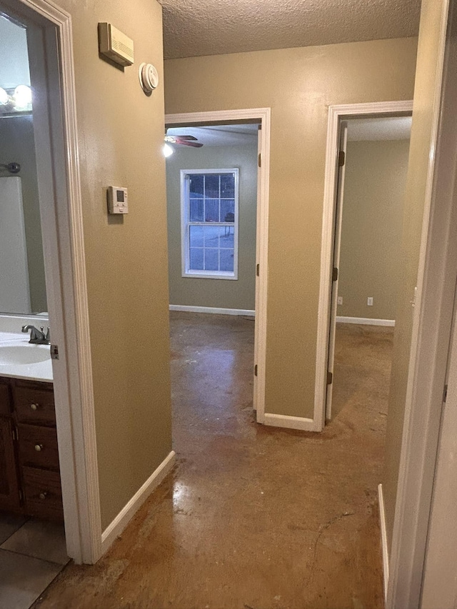 hallway with sink and a textured ceiling