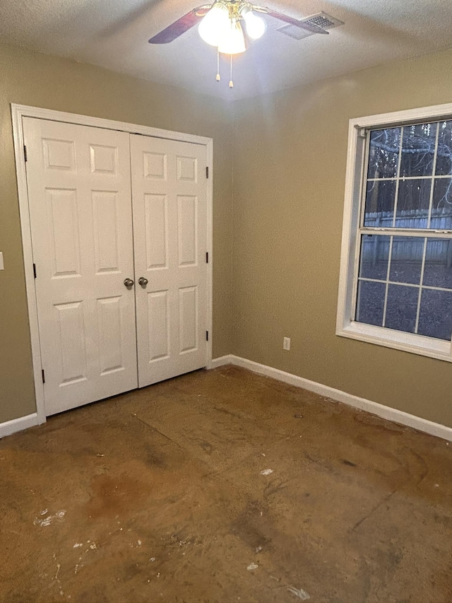 unfurnished bedroom featuring a textured ceiling, ceiling fan, and a closet