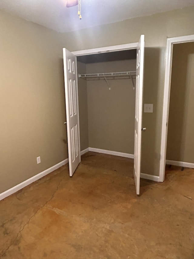 unfurnished bedroom with concrete flooring and a closet