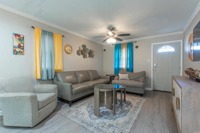 living room with hardwood / wood-style floors, ornamental molding, and ceiling fan