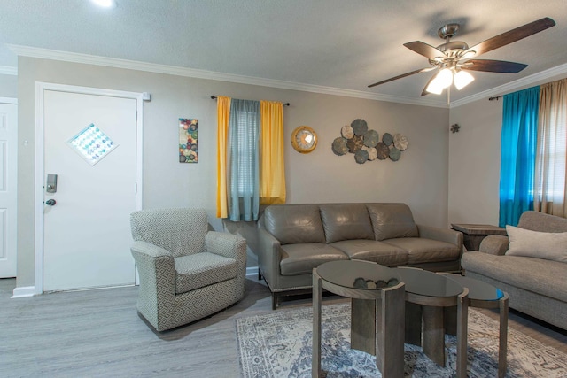 living room featuring crown molding, ceiling fan, and light hardwood / wood-style flooring