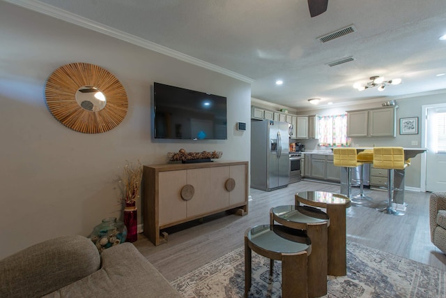 living room with crown molding and light hardwood / wood-style floors