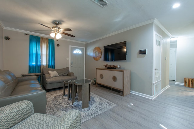 living room with radiator heating unit, crown molding, wood-type flooring, and ceiling fan