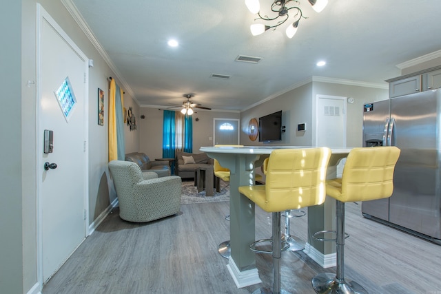 living room featuring crown molding, indoor bar, wood-type flooring, and ceiling fan