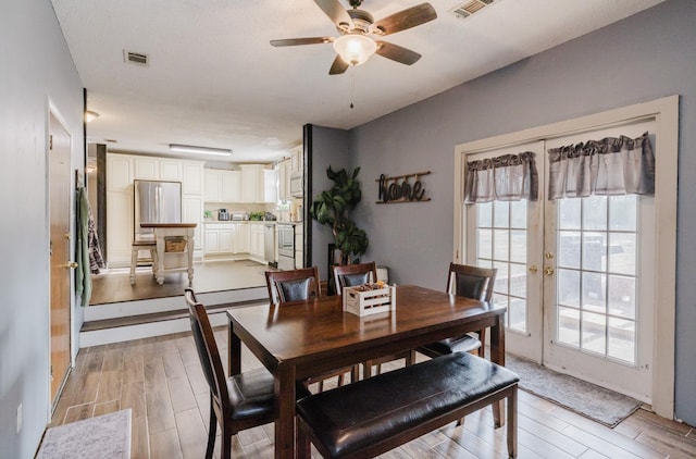 dining space featuring ceiling fan and french doors