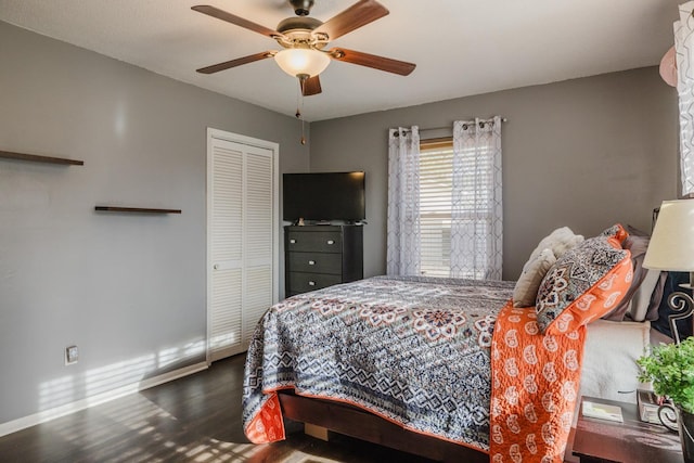 bedroom with dark wood-type flooring, ceiling fan, and a closet