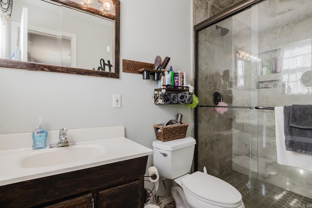 bathroom featuring toilet, vanity, and walk in shower