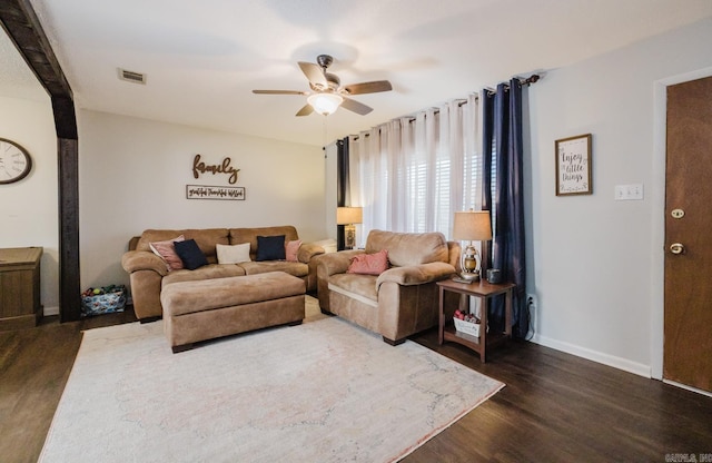 living room featuring dark wood-type flooring and ceiling fan