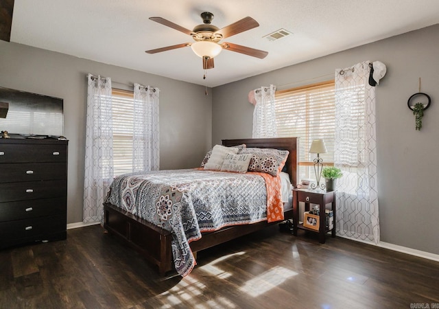 bedroom with dark hardwood / wood-style flooring and ceiling fan