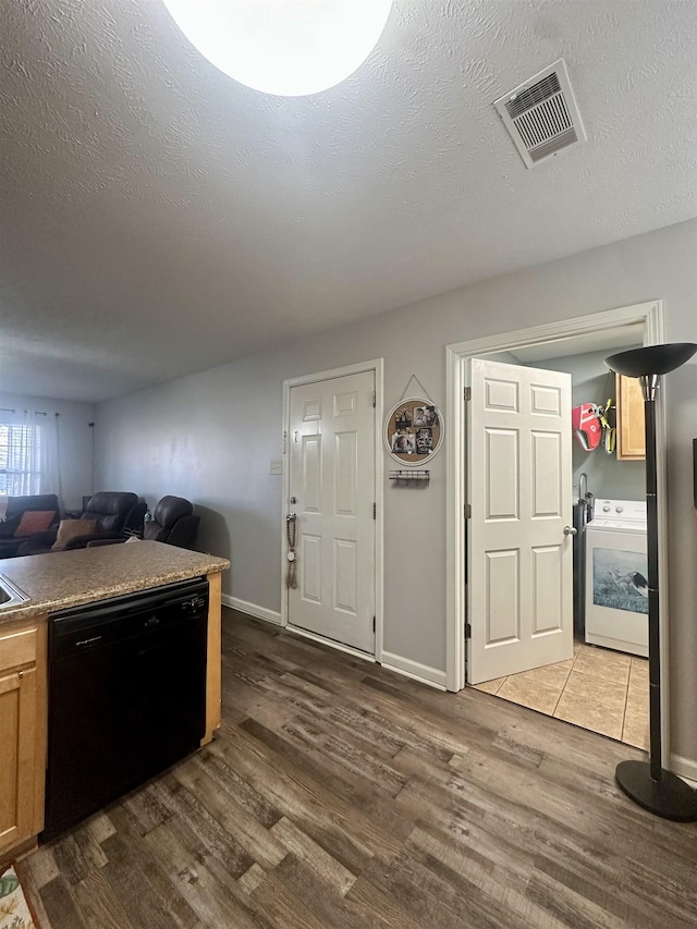 kitchen with washer / clothes dryer, a textured ceiling, hardwood / wood-style floors, and dishwasher