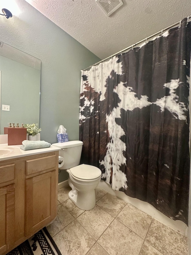 bathroom with vanity, toilet, and a textured ceiling