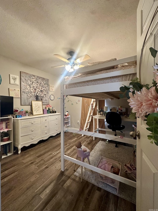 bedroom with a textured ceiling, dark wood-type flooring, and ceiling fan