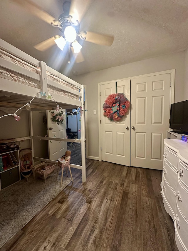 bedroom featuring ceiling fan, dark hardwood / wood-style floors, and a textured ceiling