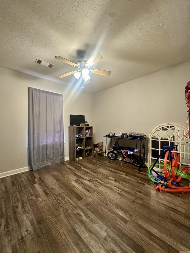 interior space featuring dark hardwood / wood-style flooring, a textured ceiling, and ceiling fan