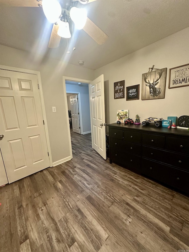 bedroom with dark hardwood / wood-style flooring and ceiling fan