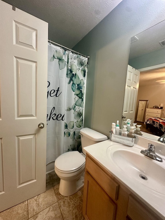 bathroom featuring vanity, toilet, and a textured ceiling