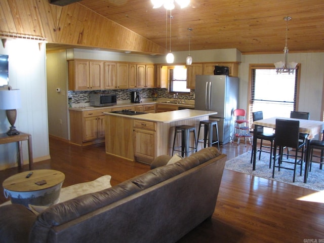 kitchen featuring decorative light fixtures, dark hardwood / wood-style floors, appliances with stainless steel finishes, and a kitchen island