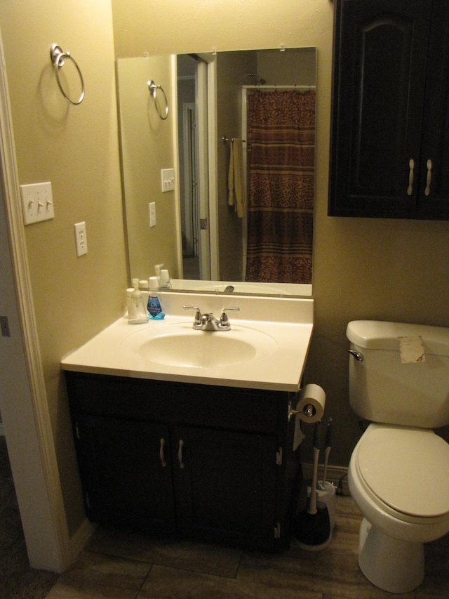 bathroom featuring vanity, a shower with shower curtain, and toilet