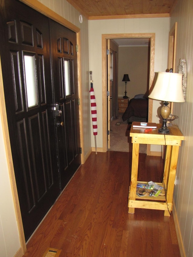 foyer featuring hardwood / wood-style flooring, wooden ceiling, and wood walls