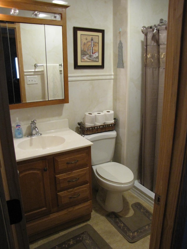 bathroom featuring vanity, curtained shower, and toilet