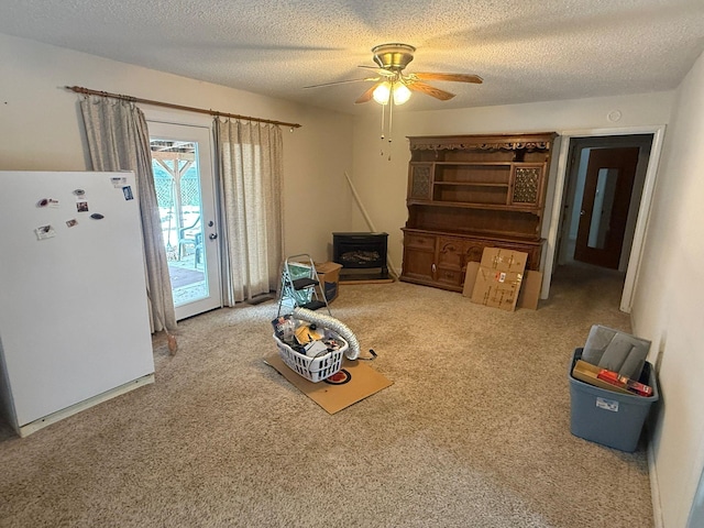 interior space featuring ceiling fan, carpet floors, and a textured ceiling